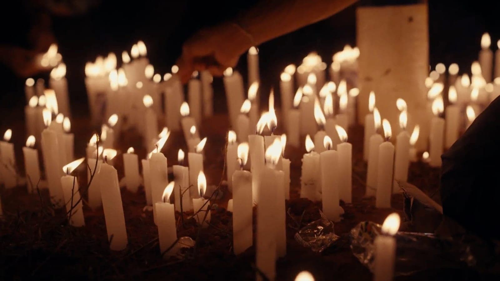 Muitas velas acesas no escuro.